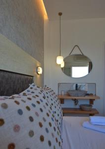 Schlafzimmer mit einem Bett und einem Spiegel in der Unterkunft Pension Votsi in Votsi