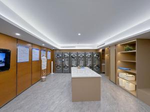 a laundry room with a row of washers and dryers at Ocean Hotel Guangzhou-Free Shuttle Bus to Canton Fair in Guangzhou