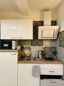 a kitchen with white cabinets and a sink at Studio Calma in Ploče