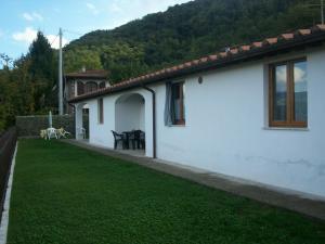 ein weißes Haus mit einem Rasenhof neben einem Haus in der Unterkunft Hermitage Holidays in Gallicano