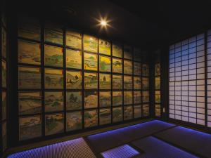 Habitación con una gran pared de pinturas. en Giappo Franca Kyoto en Kioto