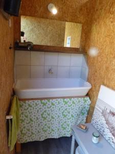 y baño con bañera, lavamanos y mesa. en Dôme géodésique au cœur de la forêt en Montignac