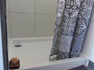 cortina de ducha en el baño con bañera en Dôme géodésique au cœur de la forêt en Montignac