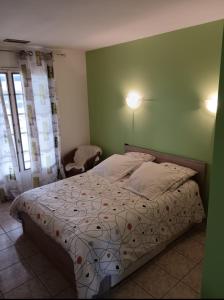 łóżko w sypialni z zieloną ścianą w obiekcie Villa, proche centre ville w mieście Verdun-sur-Garonne