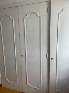 dois armários brancos com espelhos na parede em Le Korrigan em Saint-Jacques-de-la-Lande