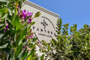 Panthea Luxury Living في كوليمفاري: وجود علامة لصيدلية بها زهور أرجوانية