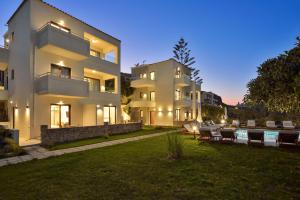 a large white building with a yard with a pool at Panthea Luxury Living in Kolymvari