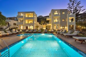 a villa with a swimming pool in front of a building at Panthea Luxury Living in Kolymvari