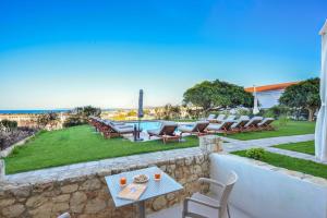 un patio con sillas, una mesa y una piscina en Panthea Luxury Living en Kolymvari