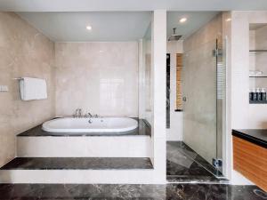 a bathroom with a tub and a shower at Urbana Langsuan Hotel in Bangkok