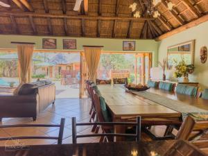 a dining room with a large wooden table and chairs at Hornbill House @ Zebula in Mabula