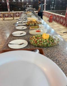 a long buffet line of plates of food on a table at Siwar Luxury Camp in Wadi Rum