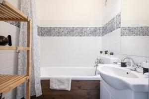 Un baño con bañera blanca y lavabo. en Lunar Love Apartment, en Budapest 13 fotos más