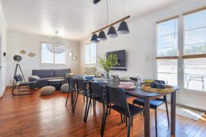 Una mesa de comedor y sillas en una sala de estar. en Maison pour 10 avec piscine chauffée, en La Barre-de-Monts