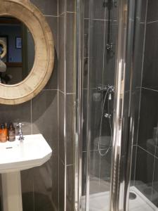 a bathroom with a shower and a sink and a mirror at Queens Head Inn & Restaurant in Hawkshead