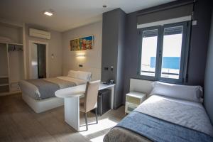 a hotel room with two beds and a table and a desk at Hotel LB Villa De Cuenca in Cuenca +144 photos