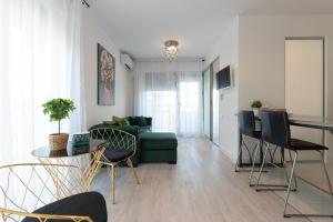 Smile Apartments في بوخارست: غرفة معيشة مع أريكة خضراء وطاولة