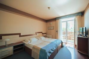 a bedroom with a bed and a television and a window at Villa Dorottya in Balatonföldvár +57 photos