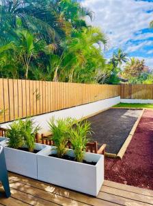 une rangée de plantes en pot assise sur un pont dans l'établissement Villa JoCeline - 4ch-4sdb - piscine chauffée - proche plage, à Saint-Paul