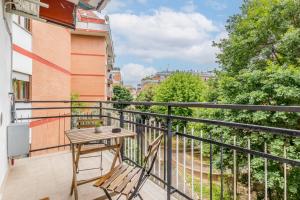 a balcony with a wooden table and a chair at Flyaway Retreat - Ciampino Apartment 15 min To Rome in Ciampino