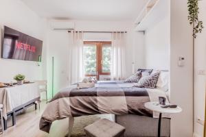a white bedroom with a bed and a table at Flyaway Retreat - Ciampino Apartment 15 min To Rome in Ciampino
