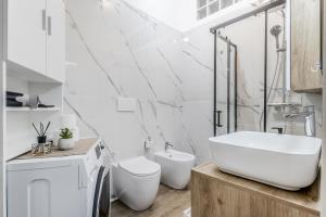 a white bathroom with a sink and a toilet at Flyaway Retreat - Ciampino Apartment 15 min To Rome in Ciampino +21 photos