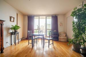 a dining room with a table and chairs and a balcony at Beautiful quiet apartment with views of Paris in Saint-Denis +12 photos