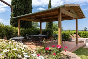 a wooden pavilion with tables and chairs in a garden at La Petrosa in Radda in Chianti