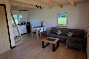 a living room with a couch and a table and a kitchen at Domki u Anitki i Nikosia in Jeleśnia