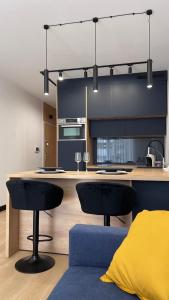 una cocina con 2 sillas negras y una isla de cocina en Apartament Poleska en Częstochowa