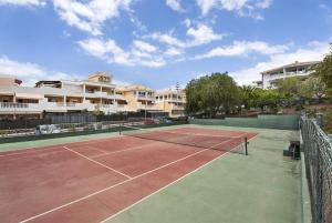 アロナにあるApto Vistahermosa 3 Bed and Poolの一部のアパートメントの建物の前にテニスコートがあります。