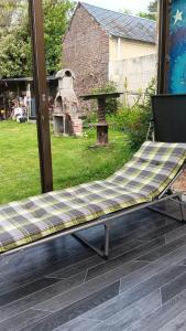 a bench on a deck with a table in a yard at Chez Vladimir in Criquebeuf-en-Caux