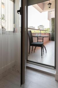 Habitación con balcón con mesa y silla. en Smile Apartments, en Bucarest
