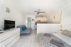 een witte kamer met een bed en een televisie bij Mareverde K131 in Adeje