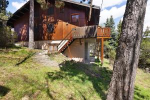 een blokhut met een veranda en een terras bij Petit chalet à Pyrénées 2000 in Font-Romeu