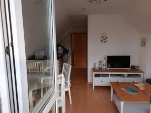 a living room with a table and a television at Die Blaue Lagune, Hinter Den Dünen in Prerow