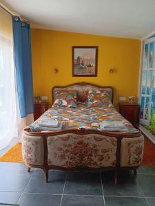 a bedroom with a bed in a yellow wall at Chez Vladimir in Criquebeuf-en-Caux