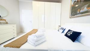 Un dormitorio con una cama blanca con toallas. en Fairmont Residence Alice by Ca-Sa Check, en Chioggia