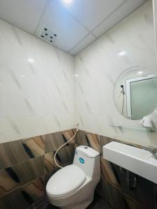 a bathroom with a toilet and a mirror and a sink at Khách sạn THUỲ DƯƠNG 1 in Ho Chi Minh City