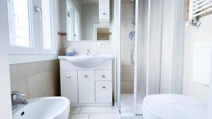 Un baño blanco con lavabo y ducha en Fairmont Residence Alice by Ca-Sa Check, en Chioggia