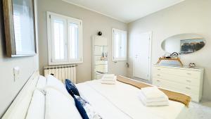 Un dormitorio blanco con una gran cama blanca y ventanas. en Fairmont Residence Alice by Ca-Sa Check, en Chioggia