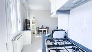Una cocina blanca con estufa y fregadero. en Fairmont Residence Alice by Ca-Sa Check, en Chioggia