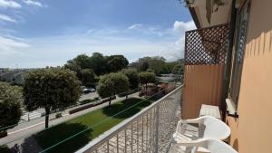 a balcony with two white chairs and a view of a street at Farmont Residence Alice by Ca-Sa Check in Chioggia