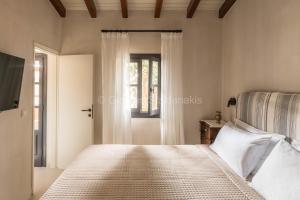 a bedroom with a bed and a window at Koutouloufari Village Holiday Club in Hersonissos