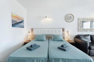 een slaapkamer met 2 aparte bedden en blauwe lakens bij Las Flores 407 in Playa Fañabe