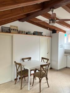 a dining room with a white table and chairs at La Mansarda di Jt in Varazze