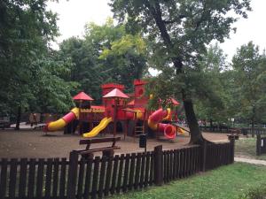 a playground with a slide in a park at Mimi Apartment in Nyíregyháza
