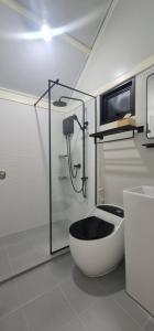 a bathroom with a tub and a shower and a toilet at Fill up mini home in Nong Prue