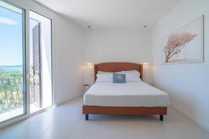 a bedroom with a bed and a large window at Dimore delle Zagare Molo in Syracuse
