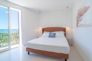 a bedroom with a bed and a large window at Dimore delle Zagare Molo in Syracuse
